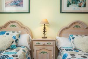a bedroom with two beds and a table with a lamp at Frente al mar in Cala Millor