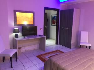 a bedroom with a bed and a desk and a tv at Mg Palace Hotel Costa del Sole in Vaccarizzo - Delfino