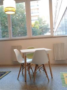 Una mesa y dos sillas en una habitación con ventanas. en elefante appartamenti, en Pescara
