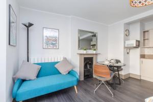 a living room with a blue couch and a table at CITY HEART BRIGHTON in Brighton & Hove