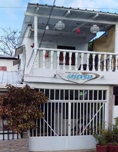 ein weißes Haus mit einem Tor und einer Veranda in der Unterkunft Comfortable inn Green Sea Villa Helen Kilometre 4 Circunvalar in La Loma