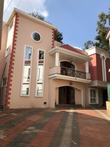 a large white house with a balcony on a brick driveway at Hillcrest Metro in Ooty