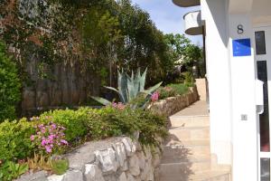a garden with flowers and a stone wall at Villa Maslina in Zadar