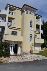 un gran edificio amarillo con balcones en la parte superior. en Villa Maslina, en Zadar