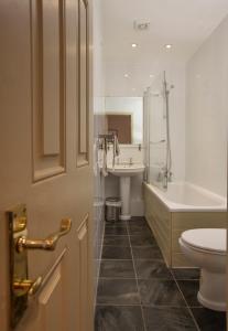 a bathroom with a toilet and a tub and a sink at Mountain Church in Capel-Curig