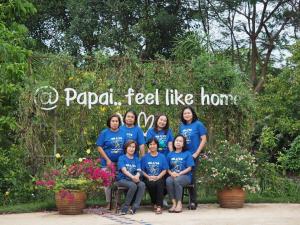 um grupo de pessoas vestindo camisas azuis em frente a uma placa em Papai Country Lodge SHA em Ban Mae Pong
