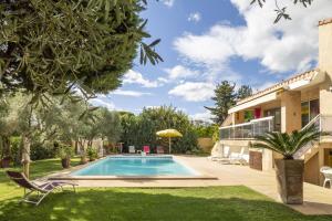 a swimming pool in a yard next to a house at Villa Noria in Vitrolles