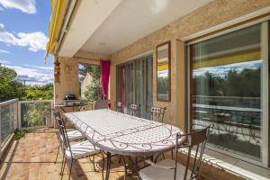 patio con mesa y sillas en el balcón en Villa Noria, en Vitrolles