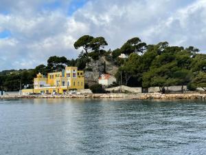 a yellow house on a island in the water at Au cœur du vieux Toulon au calme appartement rénové climatisé confortable étage élevé avec ascenseur proche parking et toutes commodités in Toulon