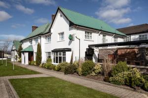 a white house with a green roof at Ivanhoe Inn and Hotel in Belfast