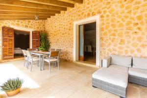 un patio avec un canapé, une table et des chaises dans l'établissement Can Cuixa, à Santa Margarita