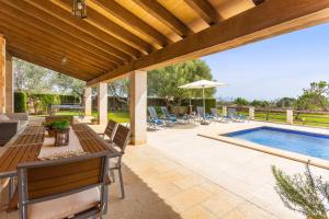 une terrasse avec un billard, des tables et des chaises dans l'établissement Can Cuixa, à Santa Margarita