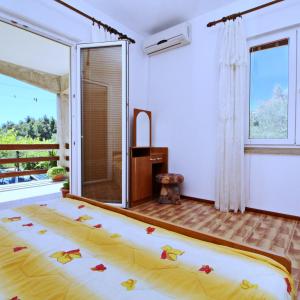Un dormitorio con una cama y una ventana grande. en Apartments Veselka, Lumbarda, en Lumbarda 39 fotos más