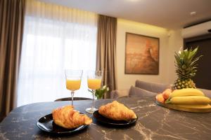 a table topped with two glasses of orange juice and biscuits at Stay in Kaunas & Park House in Kaunas
