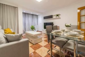 a living room with a glass table and a couch at Suite con jacuzzi en el centro vistas y garaje in Huelva