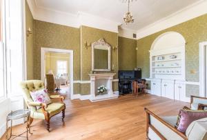 a living room with a chair and a fireplace at Reymerston Hall in Norwich