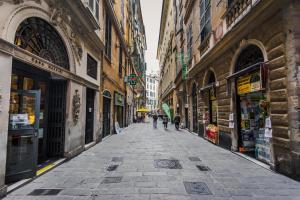 un vicolo con persone che camminano per una strada con edifici di Mini Hotel a Genova
