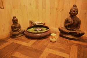 three statues sitting on the floor in a room at Westend Hotel in Matheran