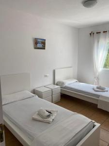 two beds in a white room with a window at Appartamento Costamar 14, Es Pujols, ALTA TURISTICA in Es Pujols
