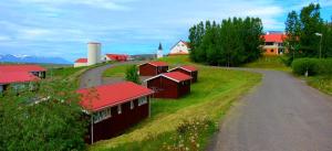 uma estrada que leva a uma quinta com telhados vermelhos em Kaffi Holar Cottages and Apartments em Sauðárkrókur