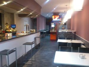 a restaurant with tables and chairs and a bar at Hostal Fisterra in Lugo