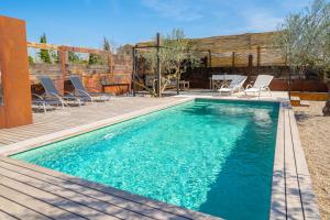 ein Pool mit einer Terrasse und Stühlen daneben in der Unterkunft Villa Angela in Palau Sator