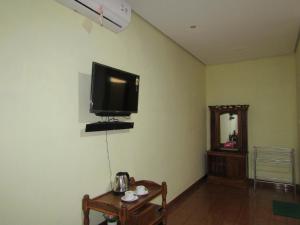 a room with a flat screen tv on the wall at Nia Maretta House Syariah in Magelang +29 photos