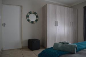 una camera da letto con un letto e uno specchio a parete di The Open Door Guest Suite a Modimolle