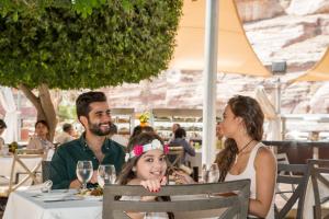 a group of people sitting at a table in a restaurant at Petra Guest House Hotel in Wadi Musa