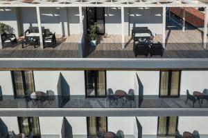 einen Balkon mit Stühlen und Tischen auf einem Gebäude in der Unterkunft Morum City Hotel Chania in Chania