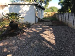 a plant in a pot on a gravel driveway at The Open Door Guest Suite in Modimolle