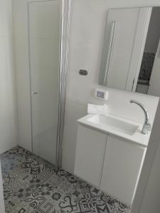 uma casa de banho com um chuveiro, um lavatório e um espelho. em יחידת נופש בבית ורדי em Tiberias