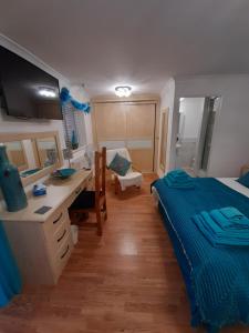 North Shore Lodge Skegness في سكيجنيس: غرفة نوم مع سرير ومكتب ومكتب