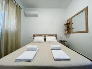 een slaapkamer met een bed met 2 kussens erop bij Archangelos Garden House in Archangelos