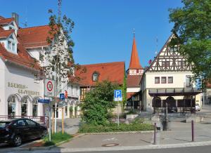 a street in a town with buildings and a car at Hotel Ditzingen in Ditzingen