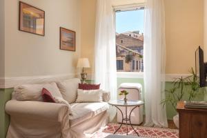 Una sala de estar con un sofá blanco y una ventana. en Porta Spilea Boutique Apartments, en Corfú