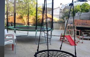 a swing set with a trampoline in a yard at Apartment Adam in Zavalatica