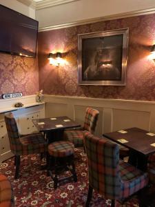 ブラックプールにあるThe Woodleigh family hotelのテーブルと椅子、壁掛けテレビ付きのレストラン
