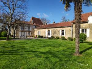 a house with a green lawn in front of it at Au Château Juillac in Juillac