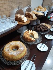 una mesa con muchos tipos diferentes de pasteles y repostería en Hotel Casarão Pitangueiras, en Guarujá