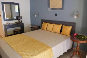 1 dormitorio con cama con almohadas amarillas y espejo en Mathesi apartment balcony, en Elia