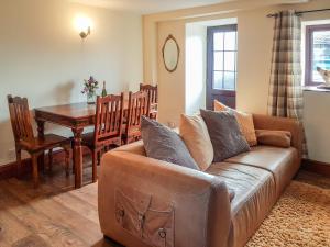 a living room with a couch and a table at Rambler's Cottage in Tansley