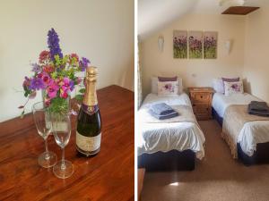 a room with a bottle of champagne and a vase of flowers at Rambler's Cottage in Tansley