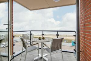 a balcony with a table and chairs and a view of an airport at DE TRINTEL met zeezicht in Egmond aan Zee