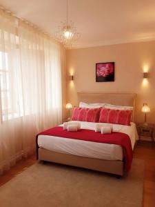 a bedroom with a large bed with red pillows at Villa Zawaia B&B in Lagos