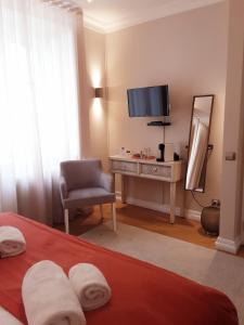 a bedroom with a bed with a desk and a television at Villa Zawaia B&B in Lagos