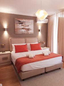 a bedroom with a large bed with red and white pillows at Villa Zawaia B&B in Lagos