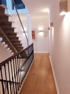 a staircase in a home with white walls and wooden floors at Villa Zawaia B&B in Lagos