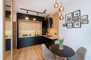 a kitchen with a table and chairs in a room at Bastion Wałowa by Q4Apartments in Gdańsk