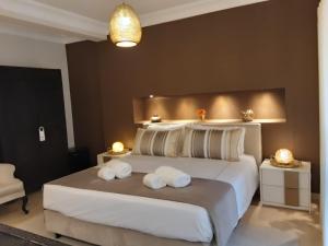 a bedroom with a large bed with two towels on it at Villa Zawaia B&B in Lagos